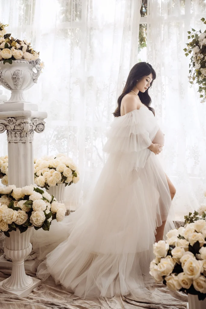 0000 0001 1 孕婦寫真,芷妤穿白色薄紗站在白色花藝場景中,雙手放在孕肚前