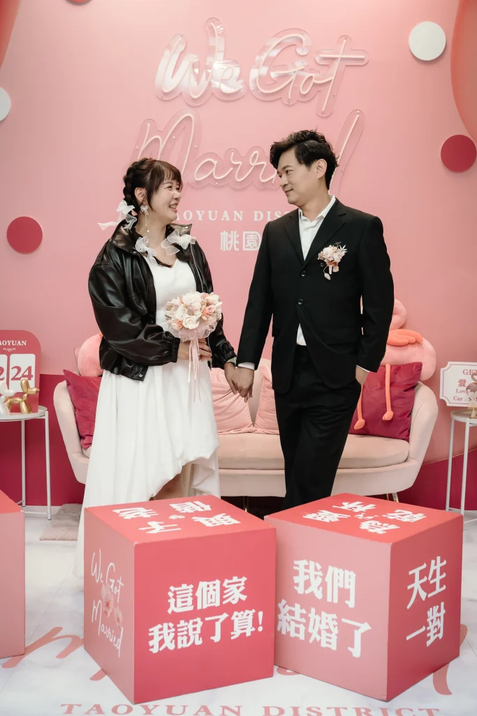 桃園戶政事務所登記結婚攝影，李小姐與蔡先生在粉色婚禮背板前合影