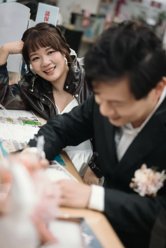 桃園戶政事務所婚攝，新郎在櫃檯前書寫結婚登記文件，新娘在旁陪伴