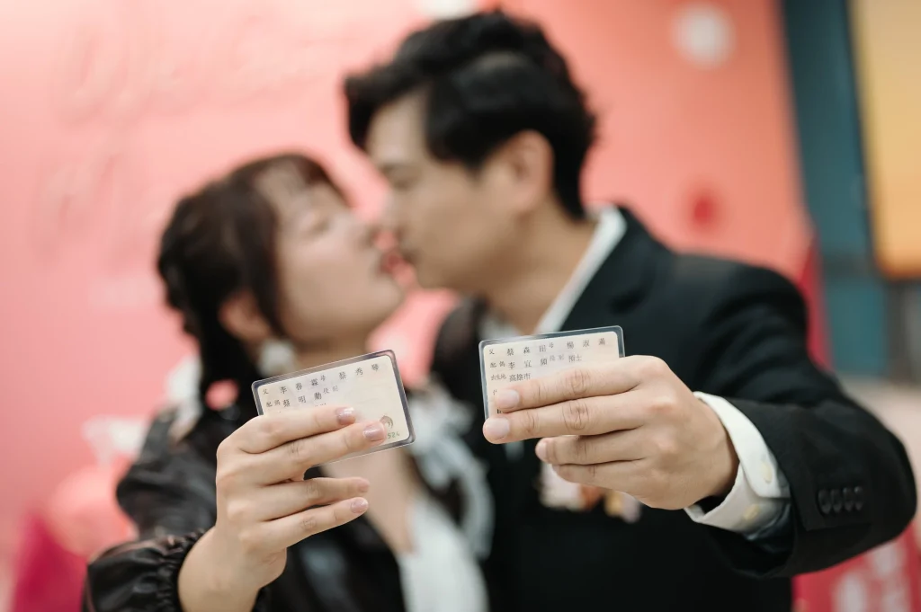 桃園登記結婚寫真，李小姐與蔡先生手持登記相關卡片並親吻合影
