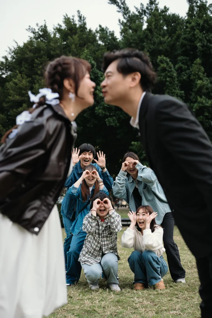 桃園結婚紀錄，新人在戶外草地親吻，親友在後方一起合照