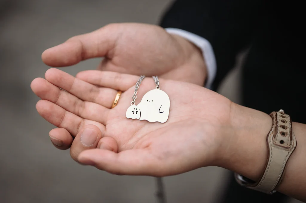 登記結婚婚攝，手掌展示結婚戒指與紀念物件的細節照