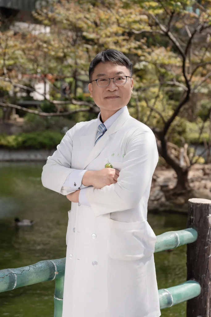 0317 0020 醫療形象攝影,白袍醫師抱胸站在湖畔欄杆旁