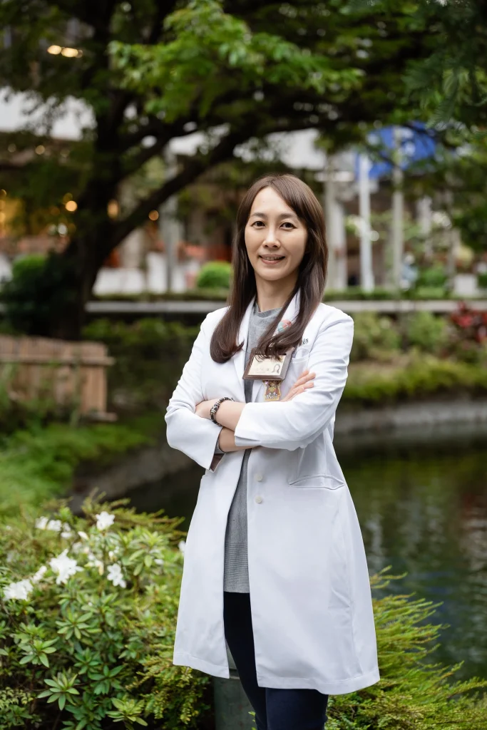 醫師形象攝影，女性醫師穿白袍站在戶外花園與水景旁