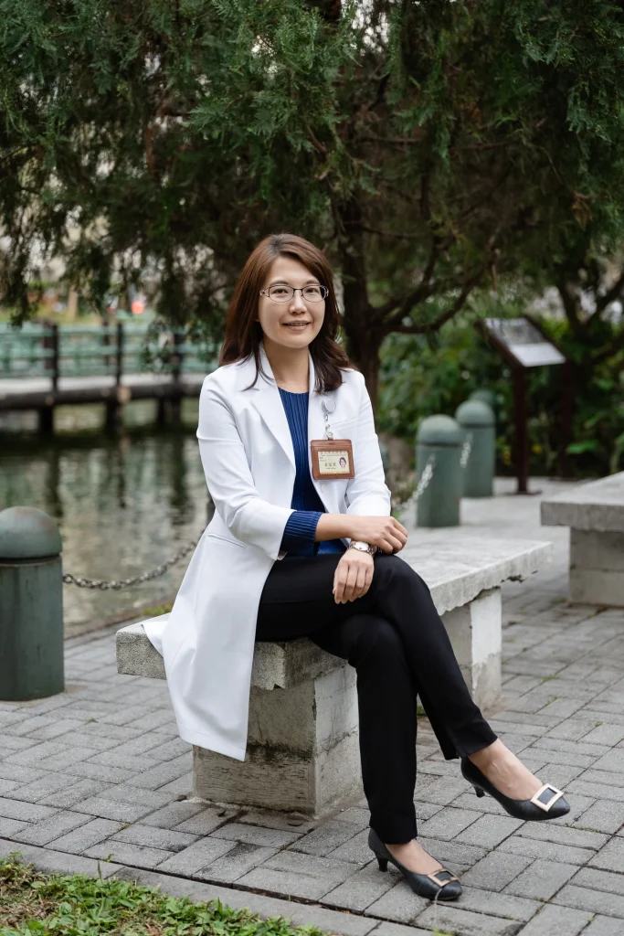 醫師形象照，女性醫師穿白袍坐在戶外水景旁