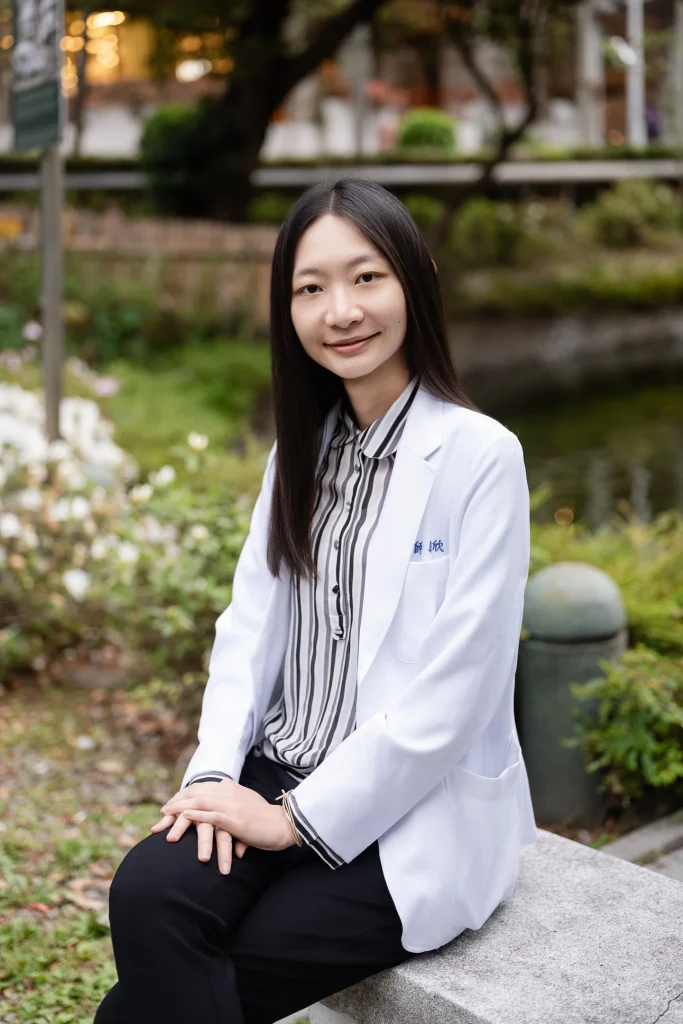 醫師形象照，女性醫師穿白袍坐在戶外花園座椅上