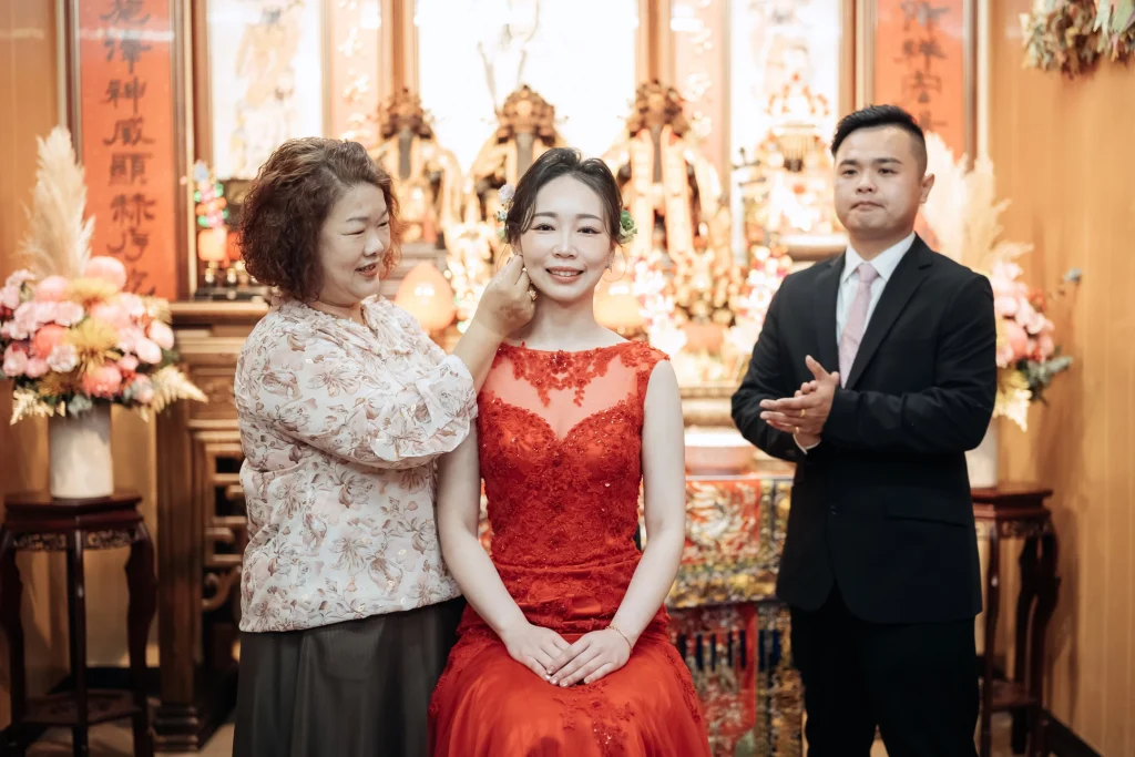 北港婚禮長輩合照，新郎新娘與婆婆長輩在神明前戴耳環