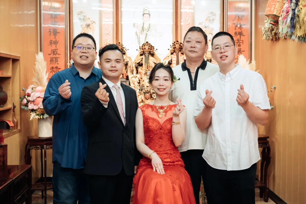 北港婚禮家人合照，新郎新娘與女方家人在神龕前留下紀錄