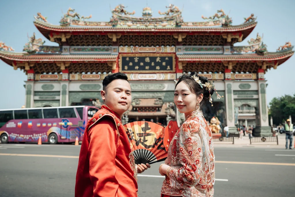 北港婚禮廟宇攝影，新郎新娘穿著傳統服飾在廟宇牌樓前合照,北港武德宮前合影