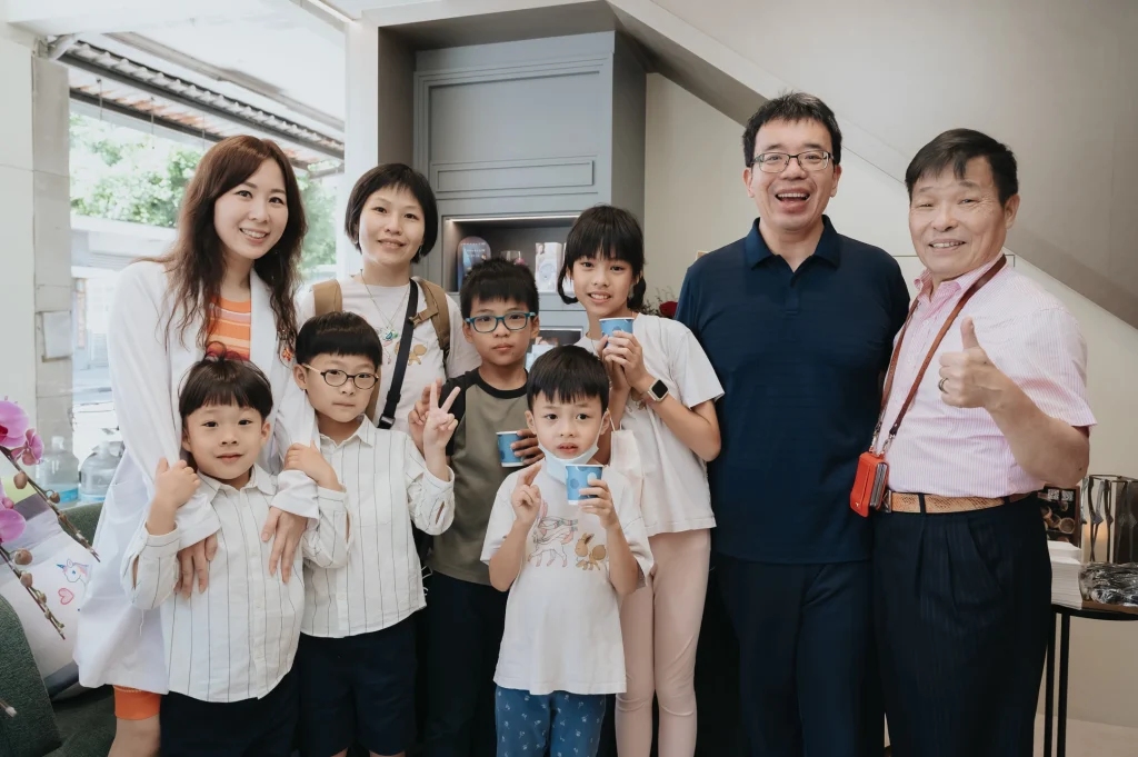0426 0003 診所開幕活動,一群親友與孩童在逐月診所內合照