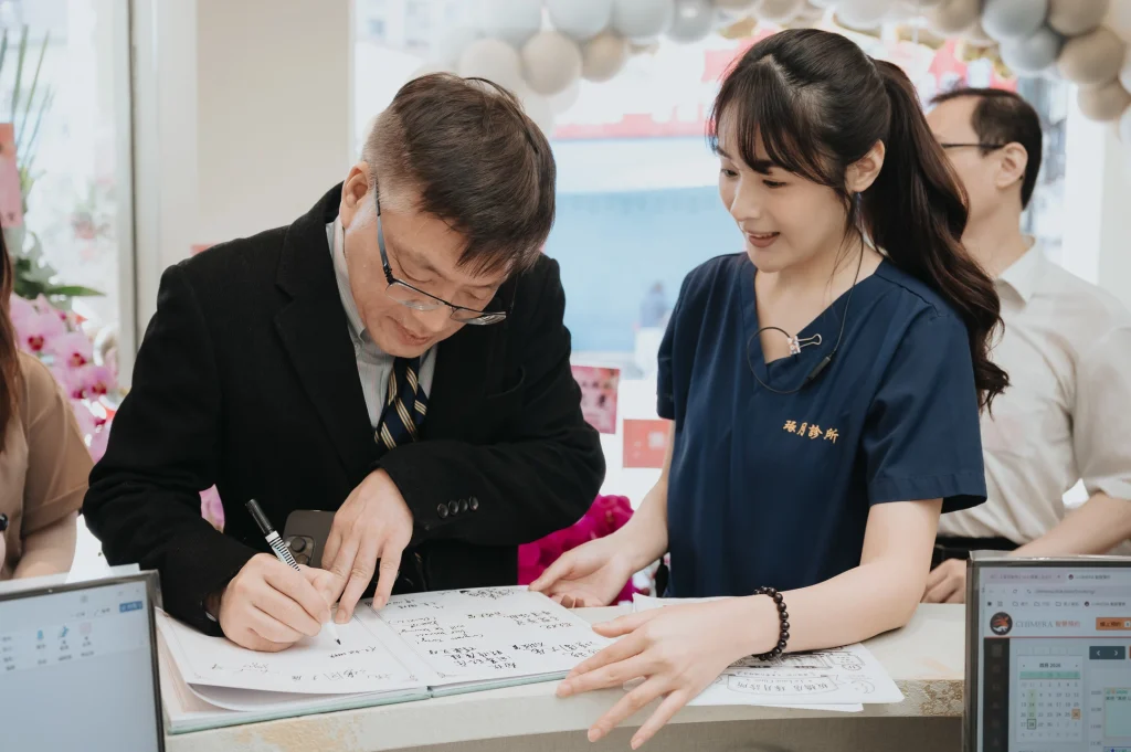 0426 0023 逐月診所開幕,來賓在櫃檯前簽寫資料