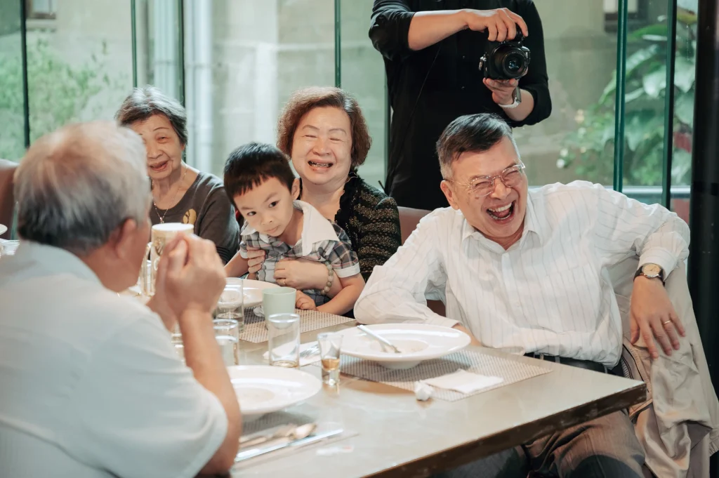 台北婚宴紀錄，親友在餐桌前大笑互動，呈現熱鬧溫暖的婚宴氣氛