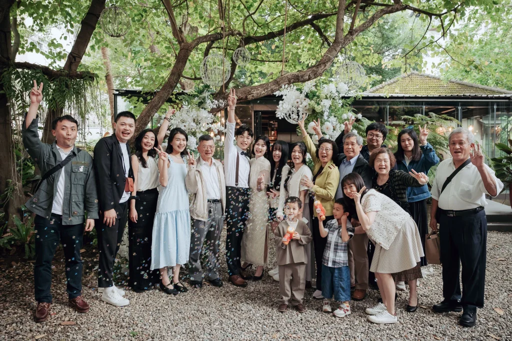 跨國婚禮親友合照，Farn 與 Tyni 和家人朋友在台北大院子戶外合影