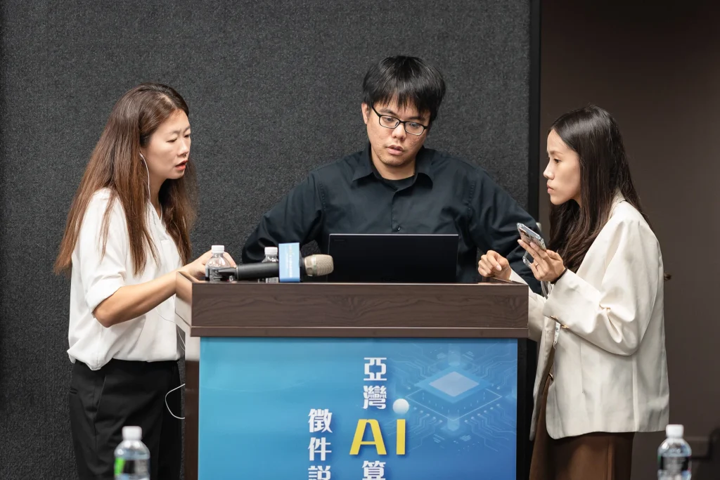 0516 0009 1 商業會議攝影,講者於講台前使用麥克風進行 AI 應用分享