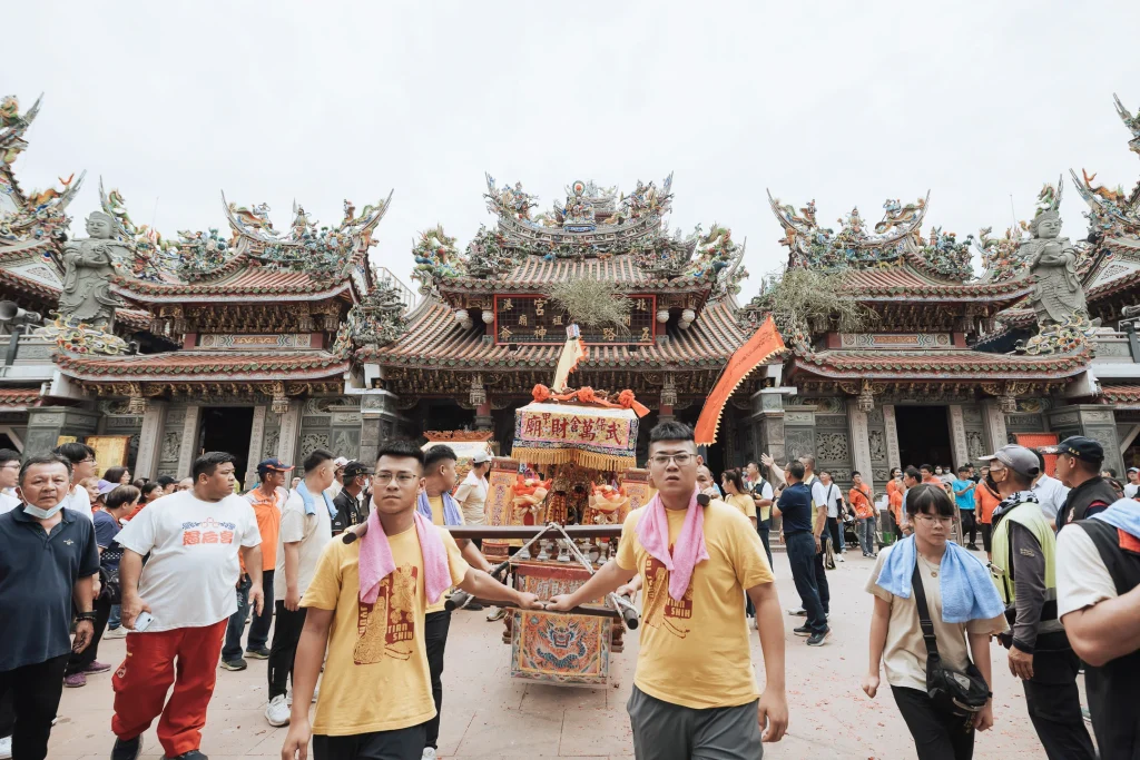 謁祖遶境紀錄，多位人員抬著神轎走出宮廟牌樓