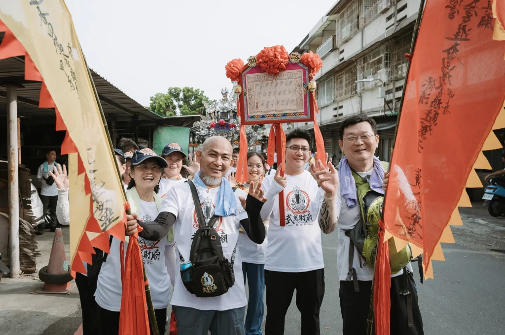 雲林活動攝影，活動人員手持旗幟與神轎在街道上合影