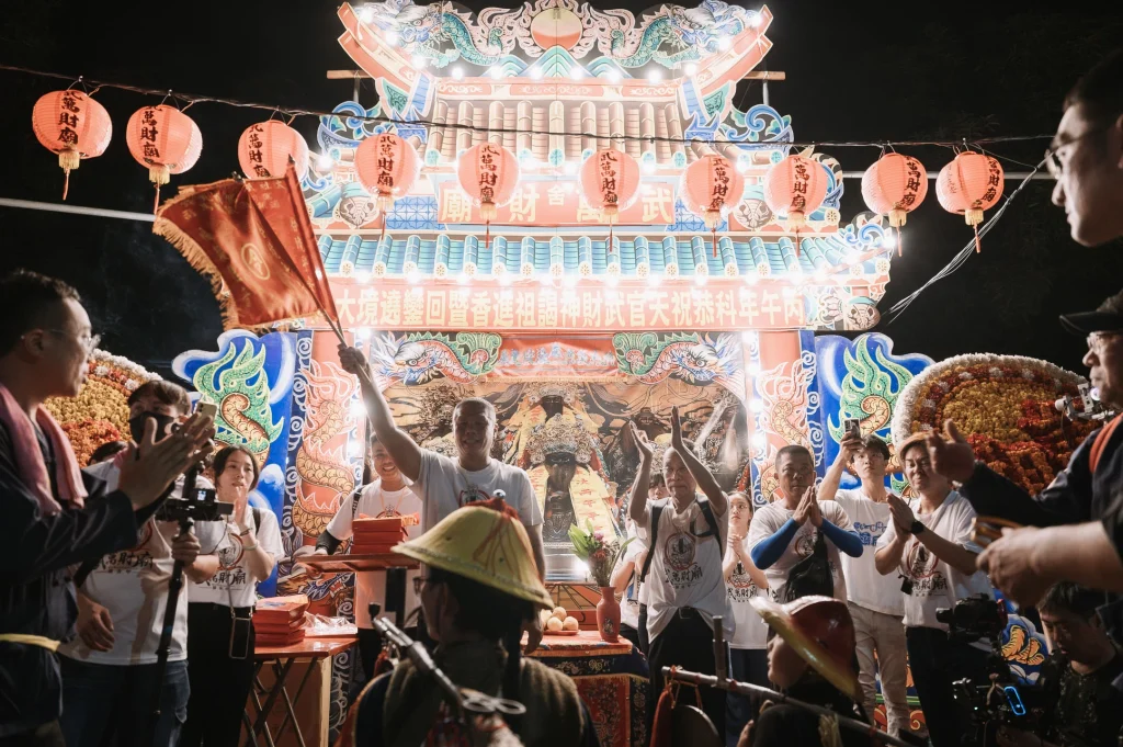 武萬財廟遶境攝影，夜間宮廟與神轎、旗幟及信眾的全景畫面