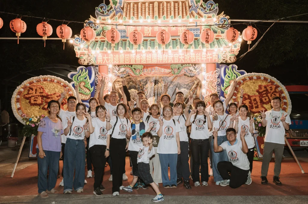 謁祖活動團體合照，信眾與活動人員在夜間大型神轎前合影